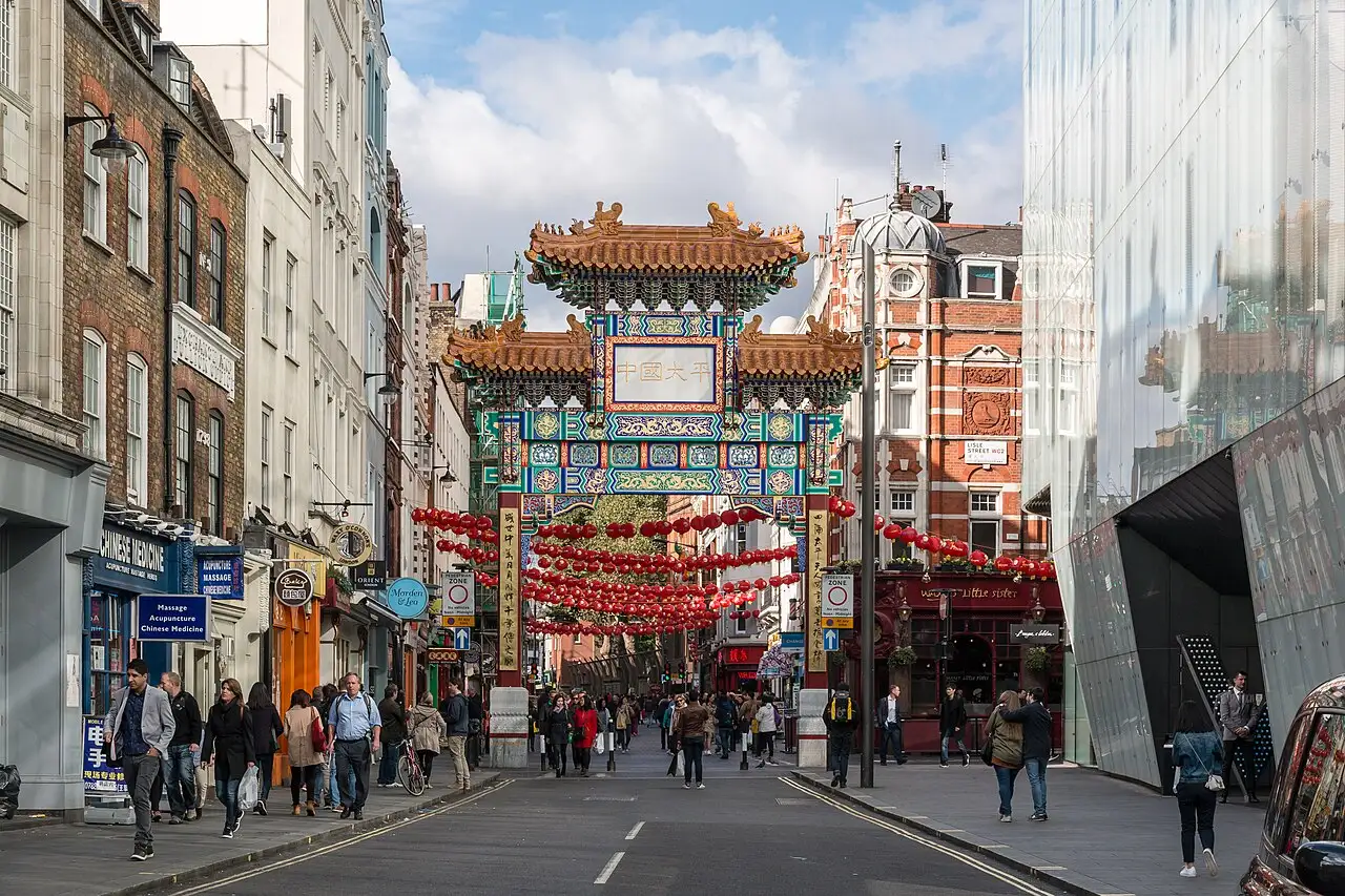 La porta cinese di Wardour Street con i tetti decorati e file di lanterne rosse sopra la strada di Chinatown