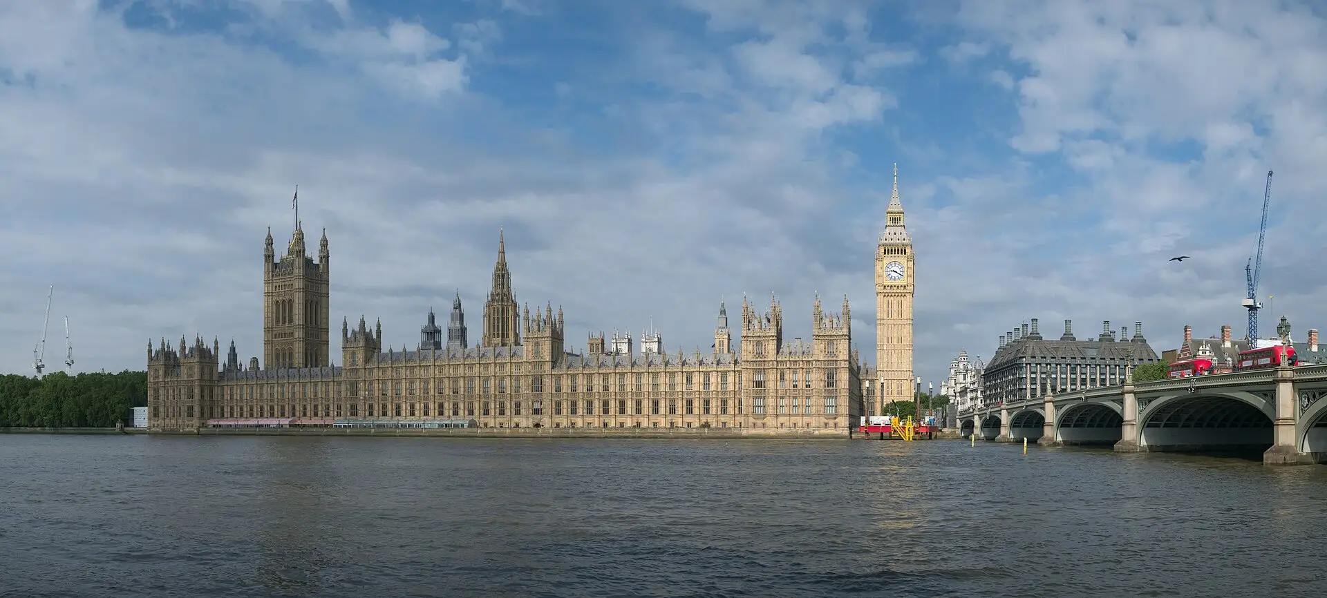Il Palazzo di Westminster e la Elizabeth Tower visti dall'altra riva del Tamigi, con gli autobus rossi sul Westminster Bridge