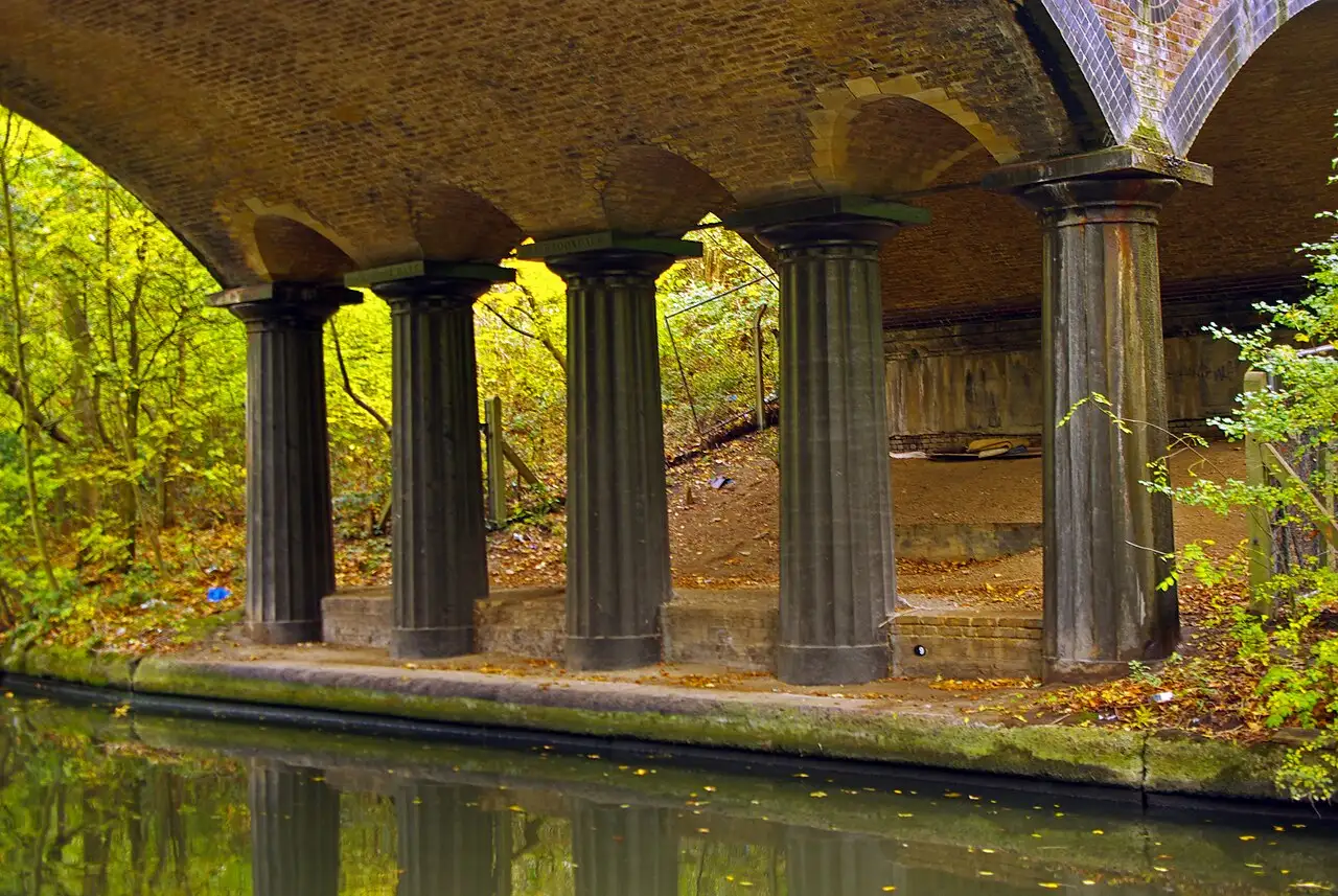 Le colonne di ghisa del Macclesfield Bridge sul Regent's Canal, riflesse nell'acqua tra alberi con le foglie d'autunno