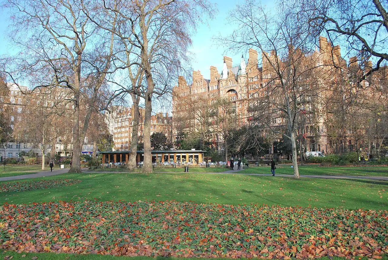 I prati di Russell Square con i platani spogli, il padiglione del caffè e, sullo sfondo, la facciata in mattoni rossi dell'hotel Kimpton Fitzroy